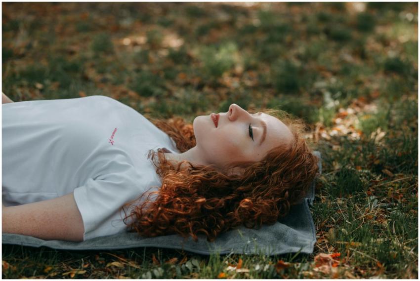 Adult woman with red hair resting peacefully outdo