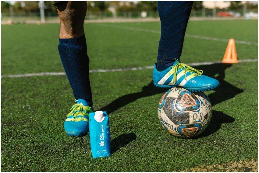 Close-up of a soccer player in blue cleats on a fi