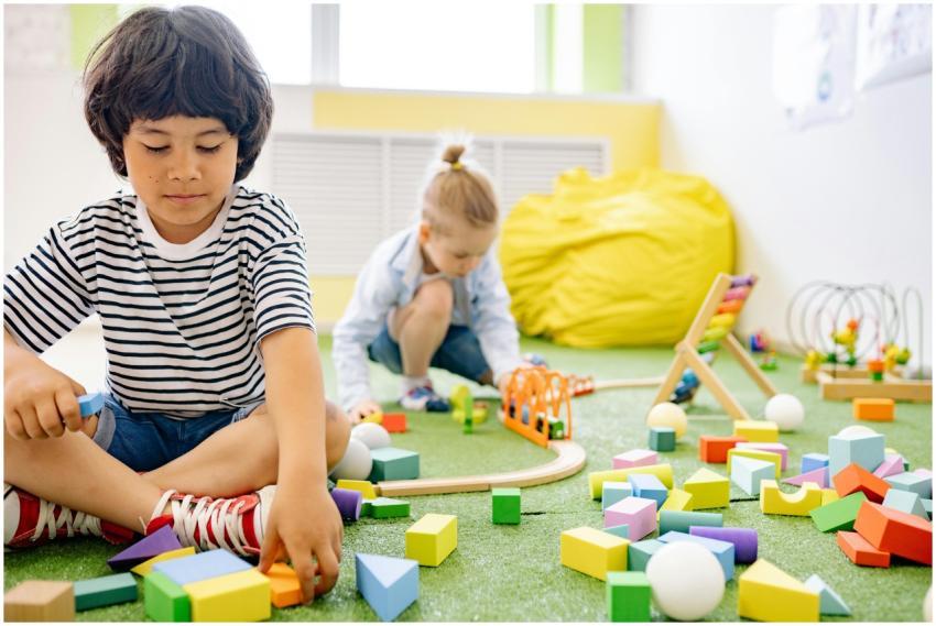Kids enjoying playtime with toys and blocks in a b