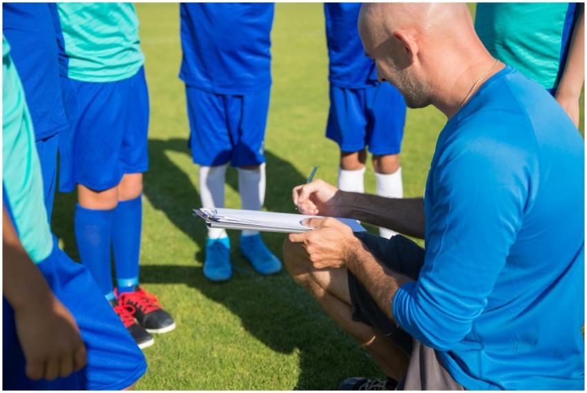 Soccer coach planning strategy with young players