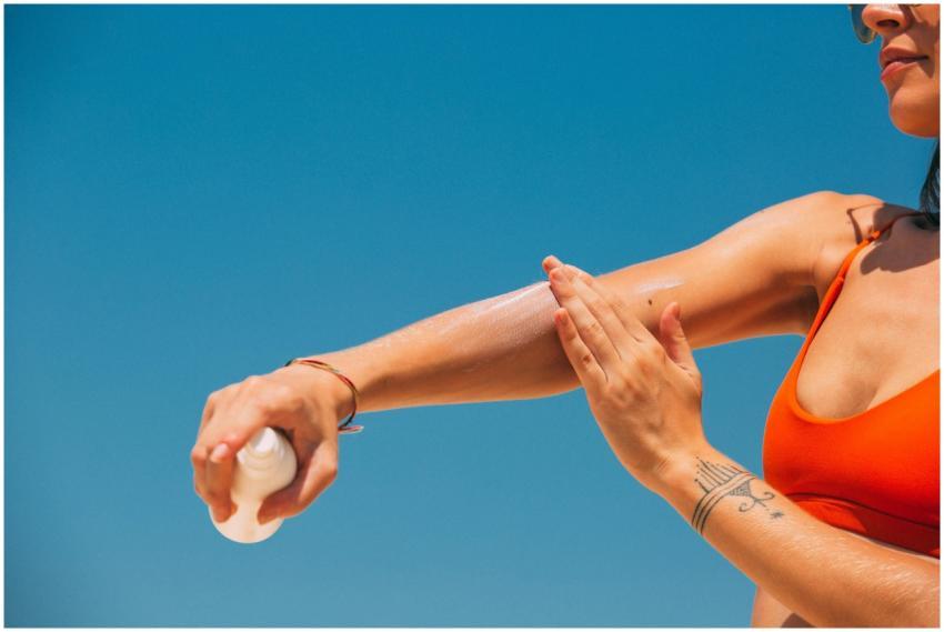 Close-up of a woman applying sunscreen on her arm