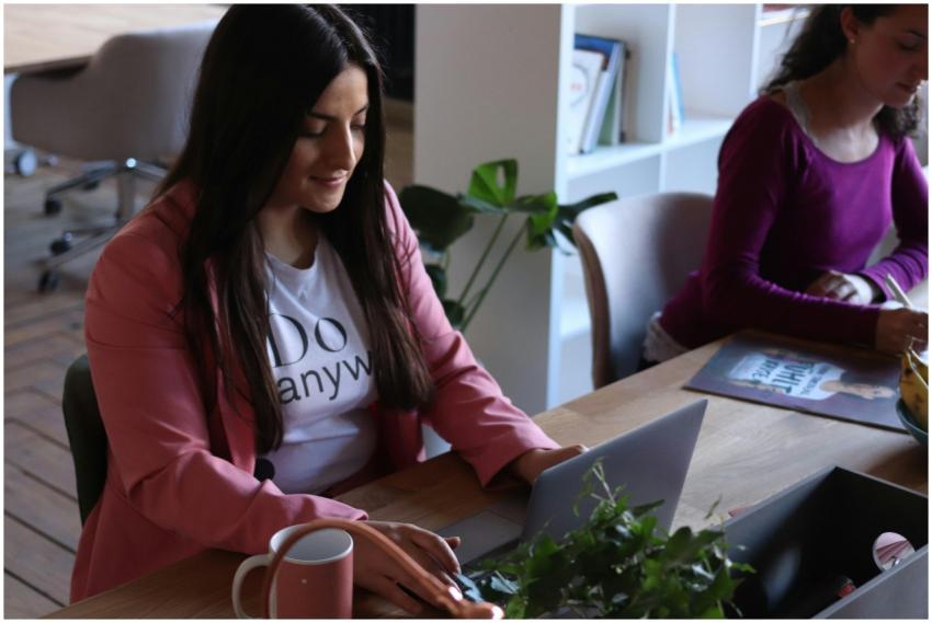Two women working at laptops in a stylish office s