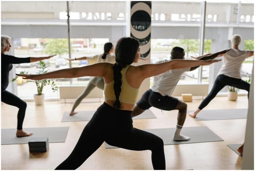A diverse group practicing yoga poses in a well-li