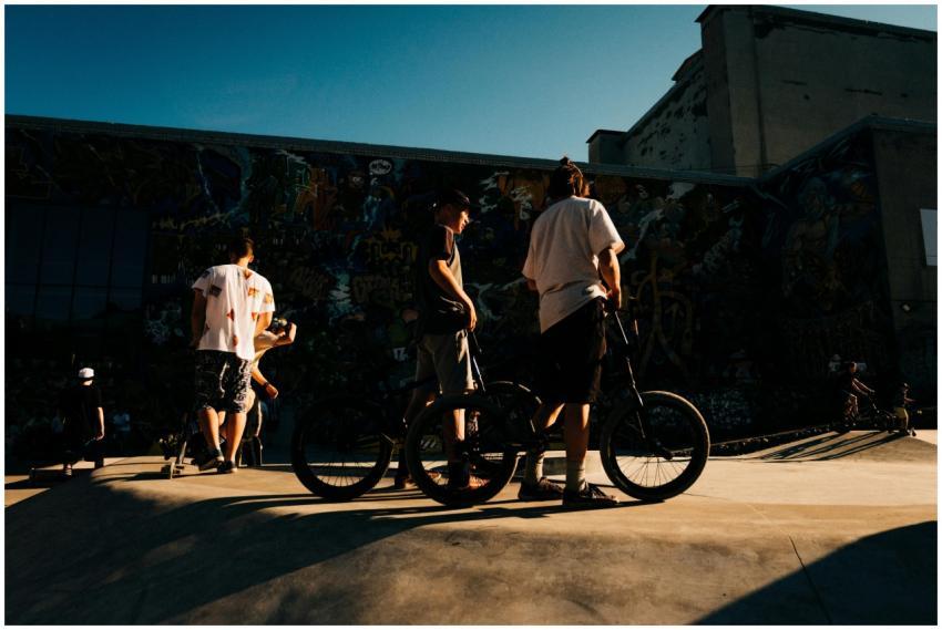A group of young individuals at a graffiti-filled