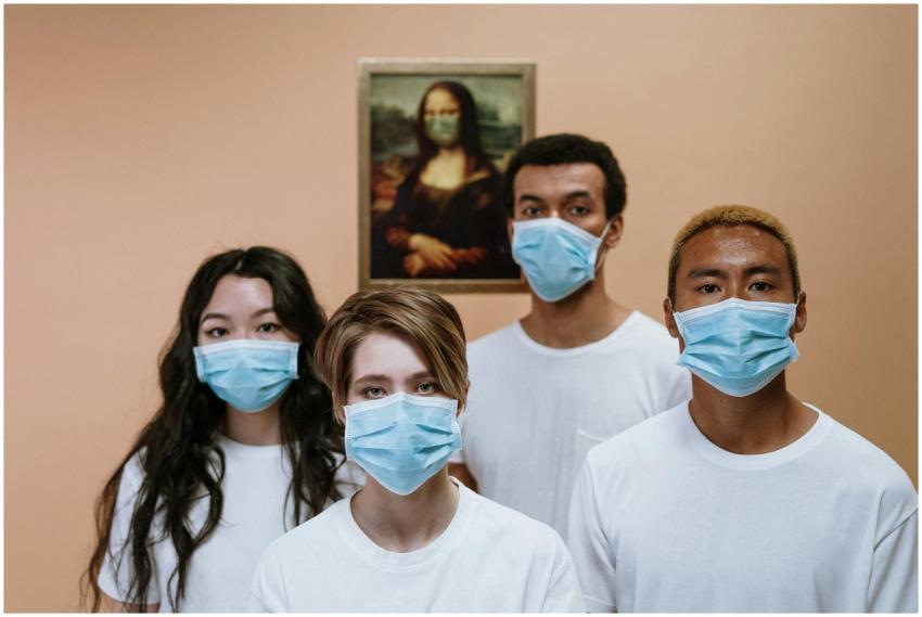 A diverse group wearing masks stands in front of a