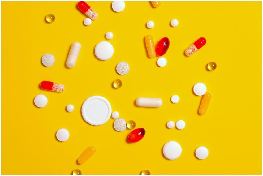 A variety of pills and capsules scattered on a vib
