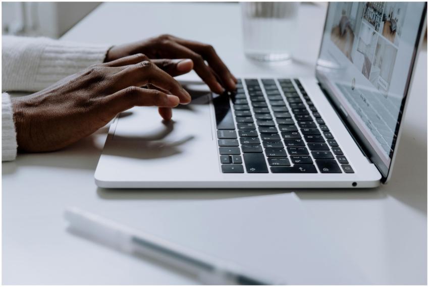 Hands typing on a sleek laptop keyboard, illustrat
