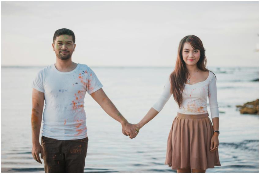 A cheerful couple holding hands by the sea, enjoyi