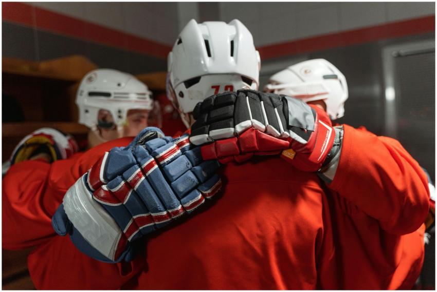 Ice hockey players huddle together in a dressing r