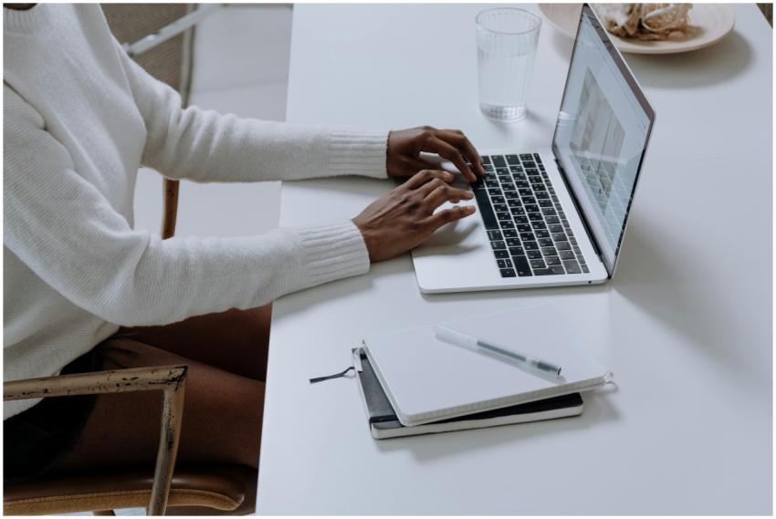 A person typing on a laptop in a minimalistic home
