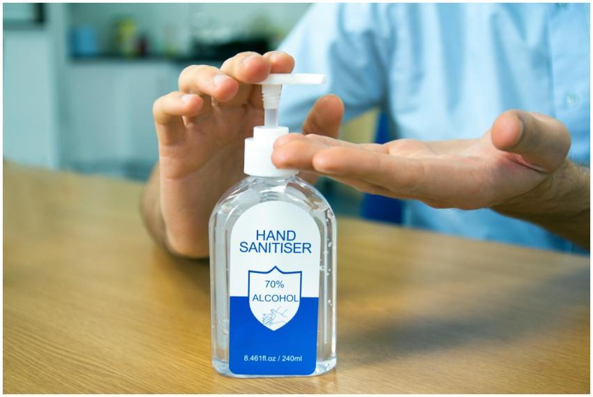 Close-up of hands using 70% alcohol hand sanitizer