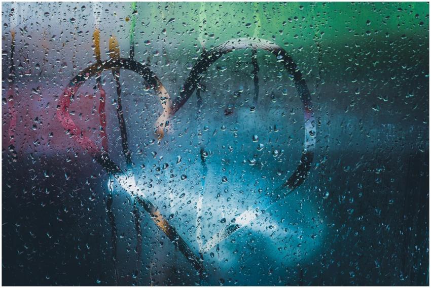 Window with raindrops and a heart drawing, capturi