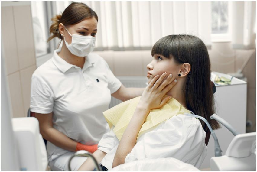 A dentist examining a young woman with toothache i