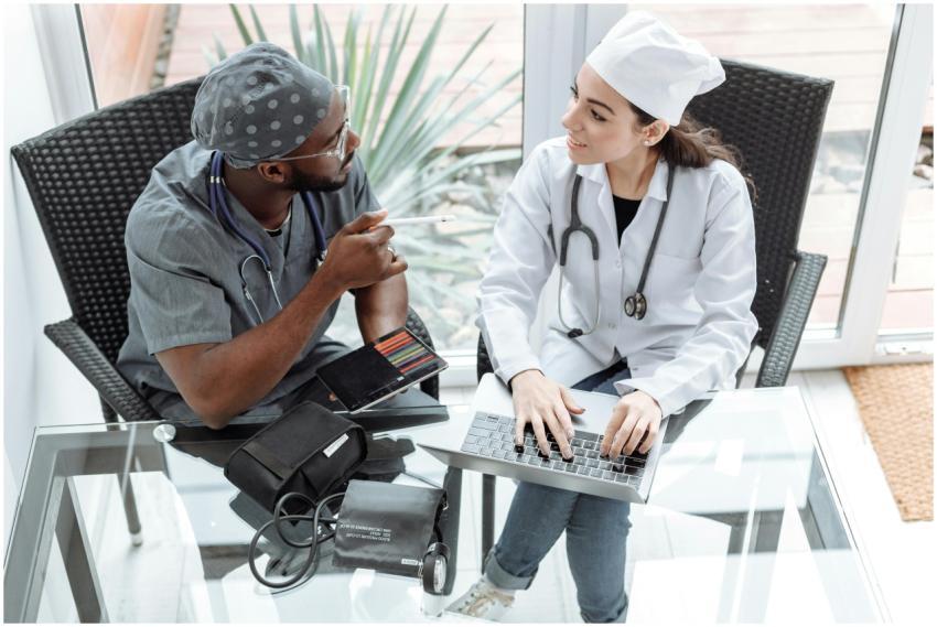 Two doctors discussing patient care using a laptop