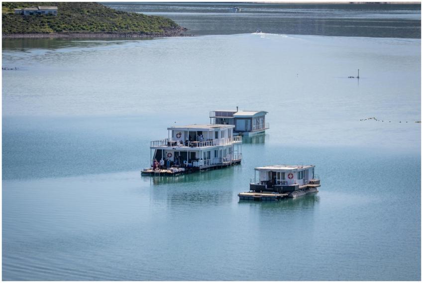 Three luxury houseboats float peacefully in the se