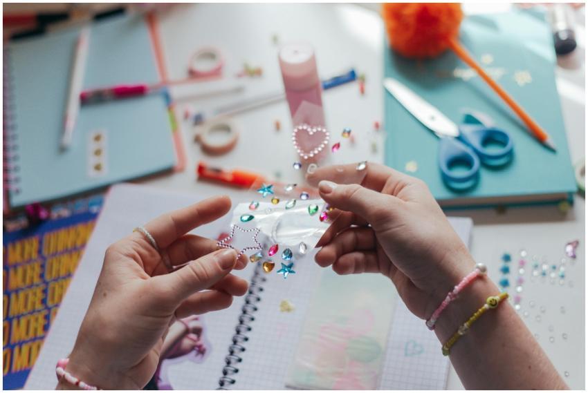 Hands decorating a notebook with colorful stickers