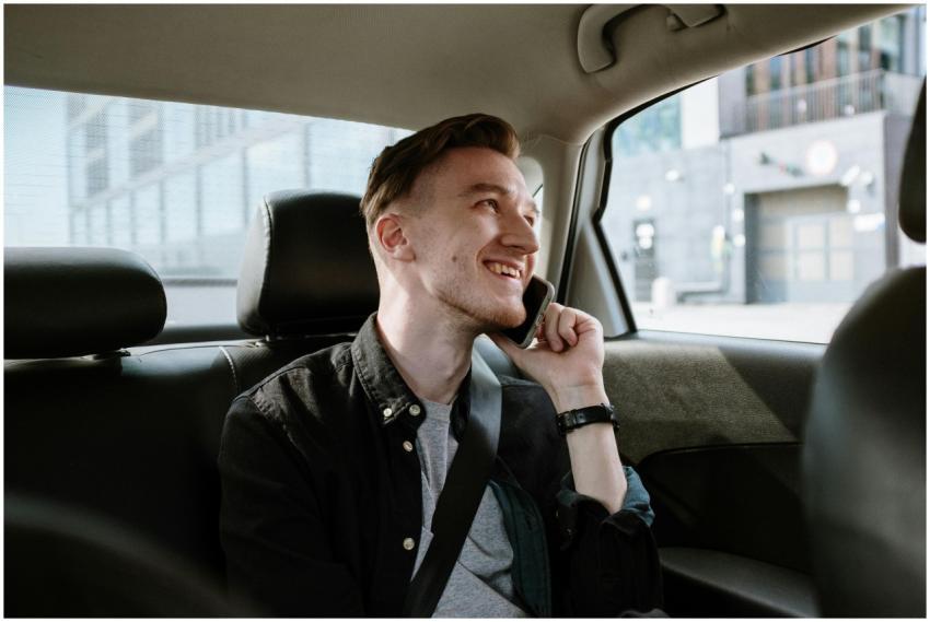 Smiling young man enjoying a phone call while seat