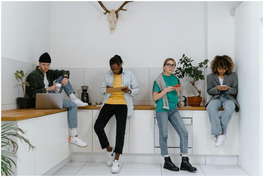 Casual and diverse colleagues using gadgets in a m