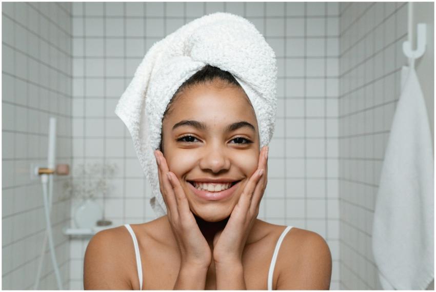 A young woman smiles during her morning skincare r