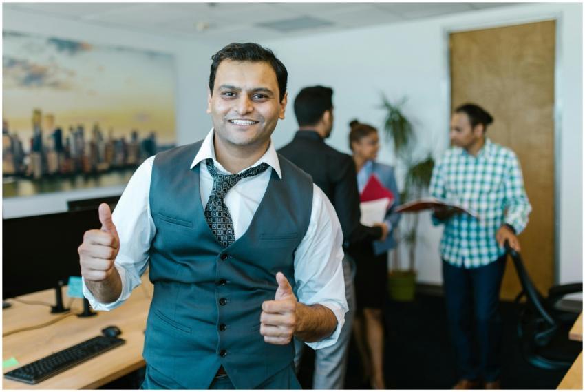 Smiling businessman showing thumbs up in a lively