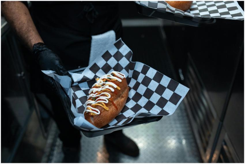 Delicious hot dog with toppings served in a commer