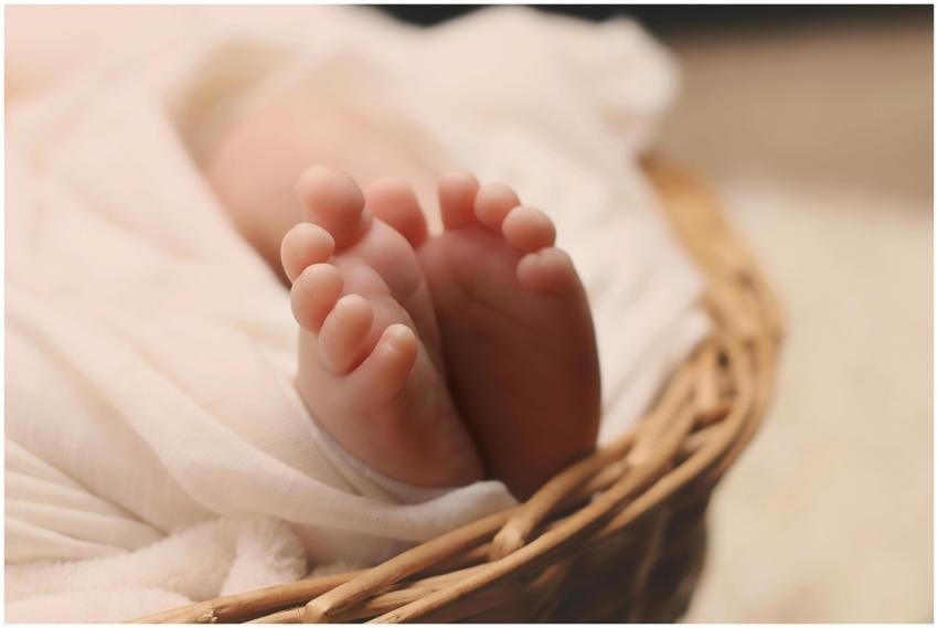 Adorable tiny newborn baby feet wrapped in a soft