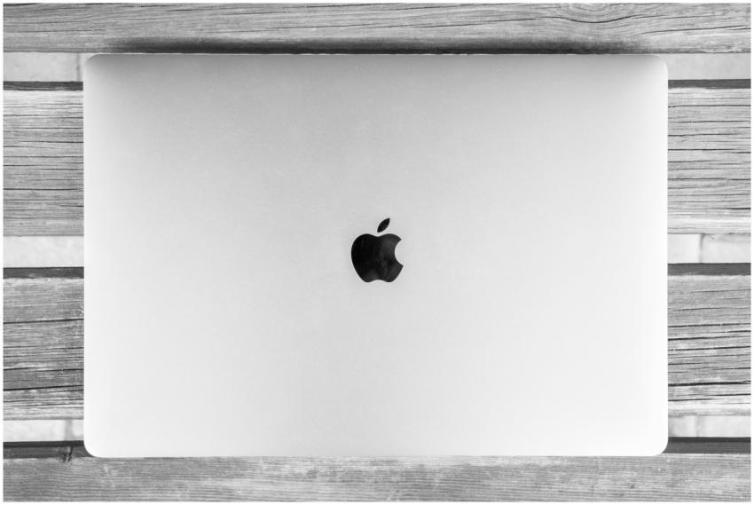 Black and white photo of a closed laptop on a rust