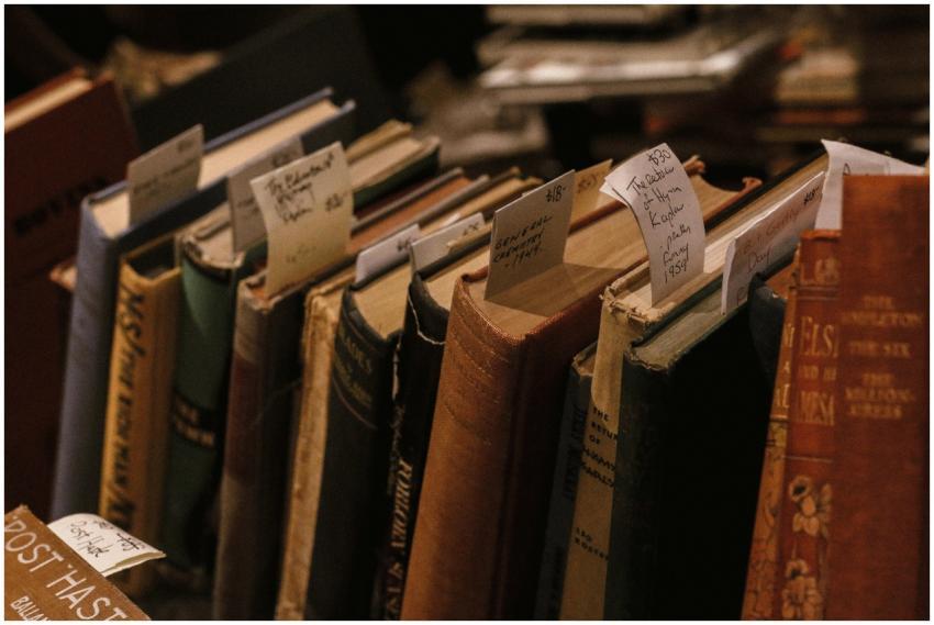 A row of vintage books displayed with handwritten