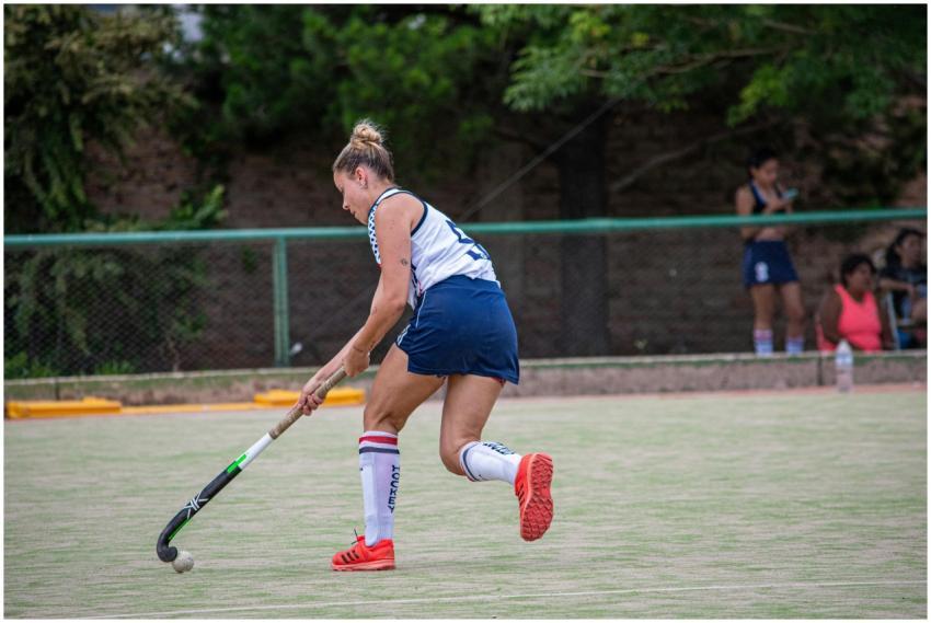 Young woman playing field hockey on a sunny day ou
