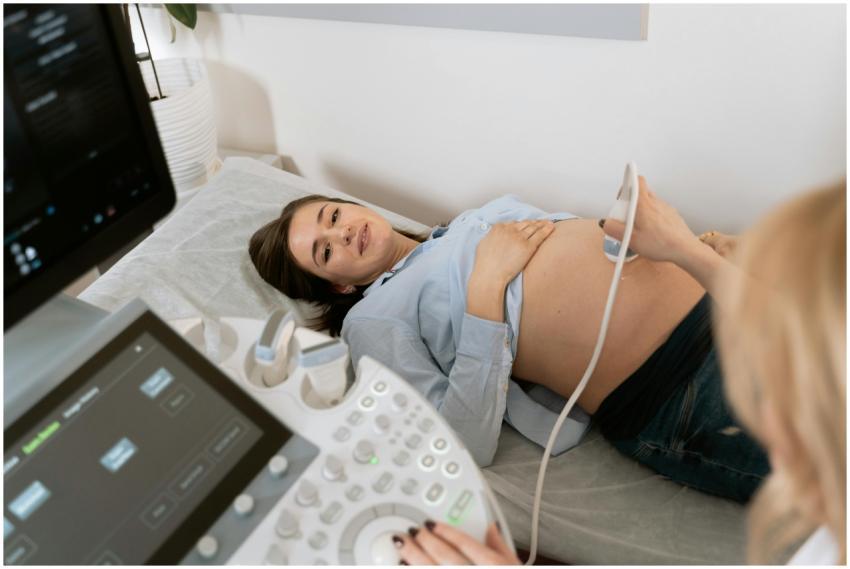 Pregnant woman undergoing an ultrasound scan, assi