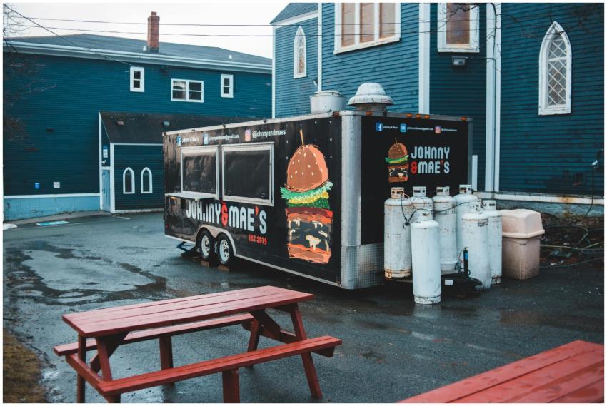From above of food truck placed on wet asphalt are