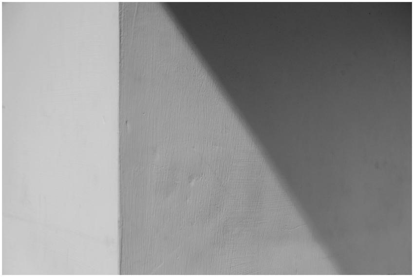 Abstract view of a cornered concrete wall with lig