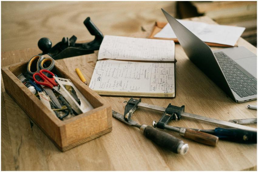 A creative woodworking workspace with tools, noteb