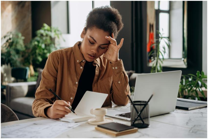 African American woman writing in notebook at a mo