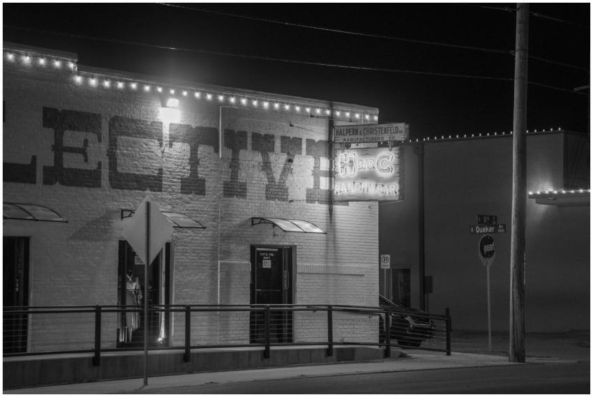 A black and white photo of a storefront with neon