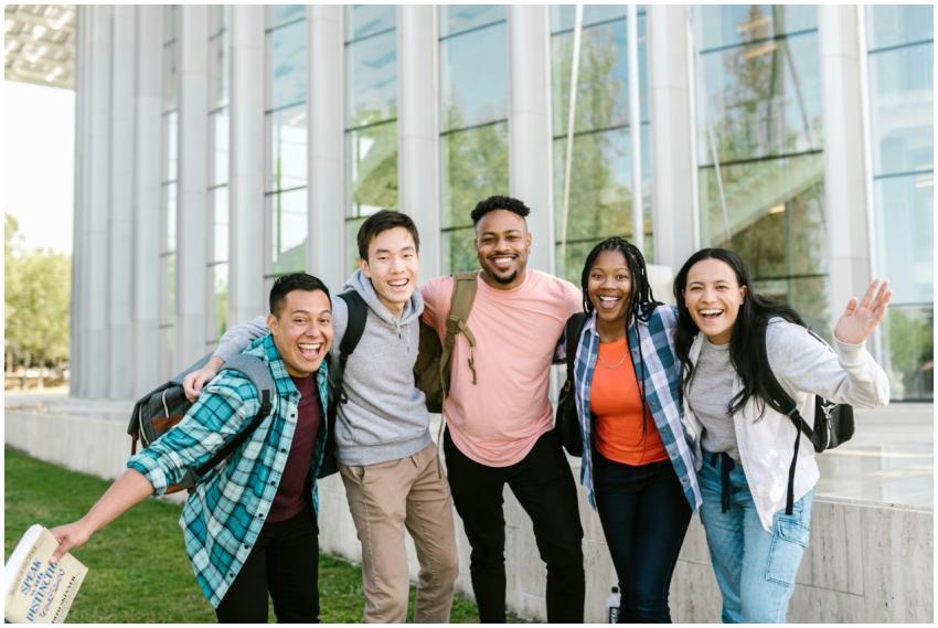 A happy group of diverse college students posing c