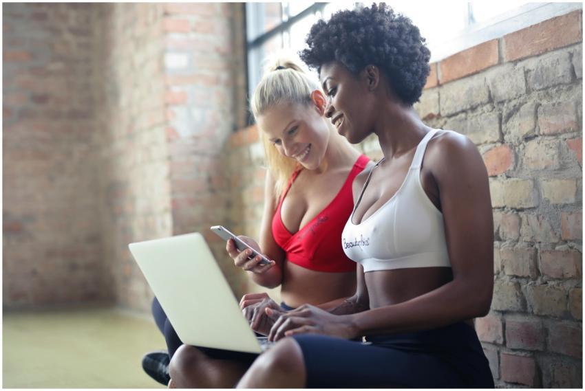 Two women in sportswear enjoy leisure time, sharin