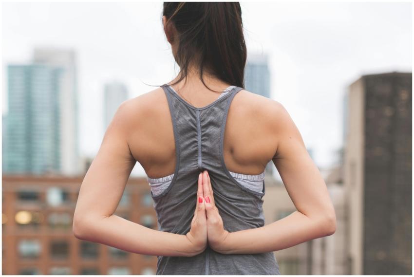 Woman performing yoga with hands in reverse prayer