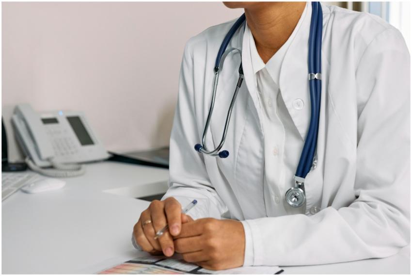 Doctor with stethoscope and white coat seated at a