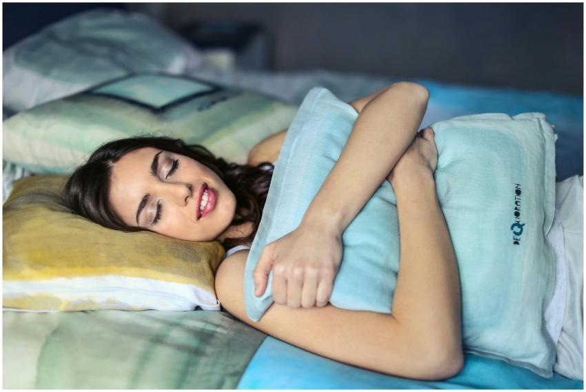 A woman sleeping peacefully in bed hugging a soft