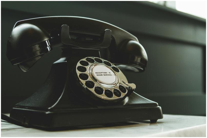 Classic black rotary phone on hotel reception desk