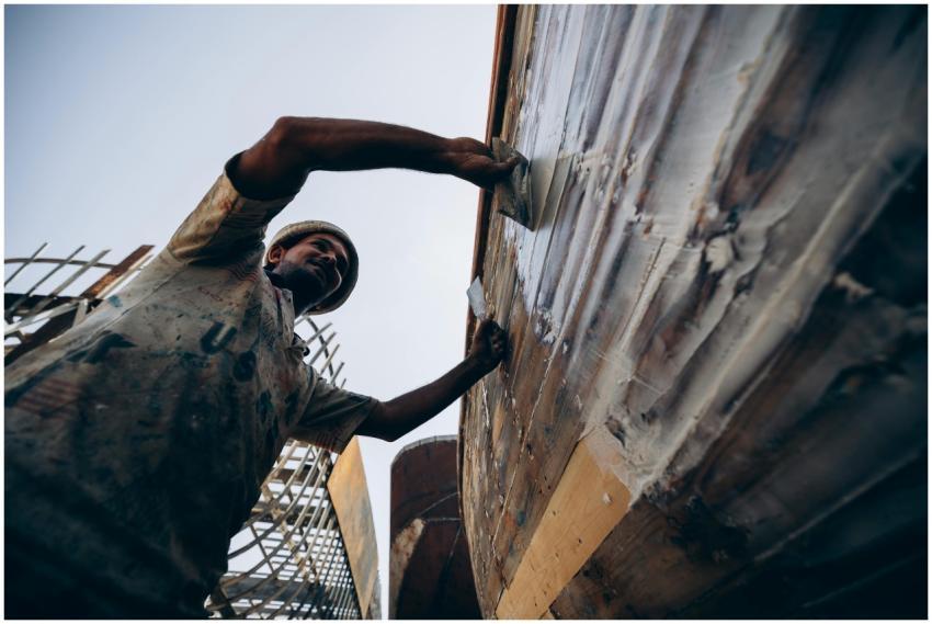 A craftsman skillfully restores a wooden boat in D