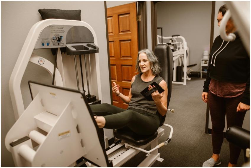 Senior woman working out on a leg press machine wi