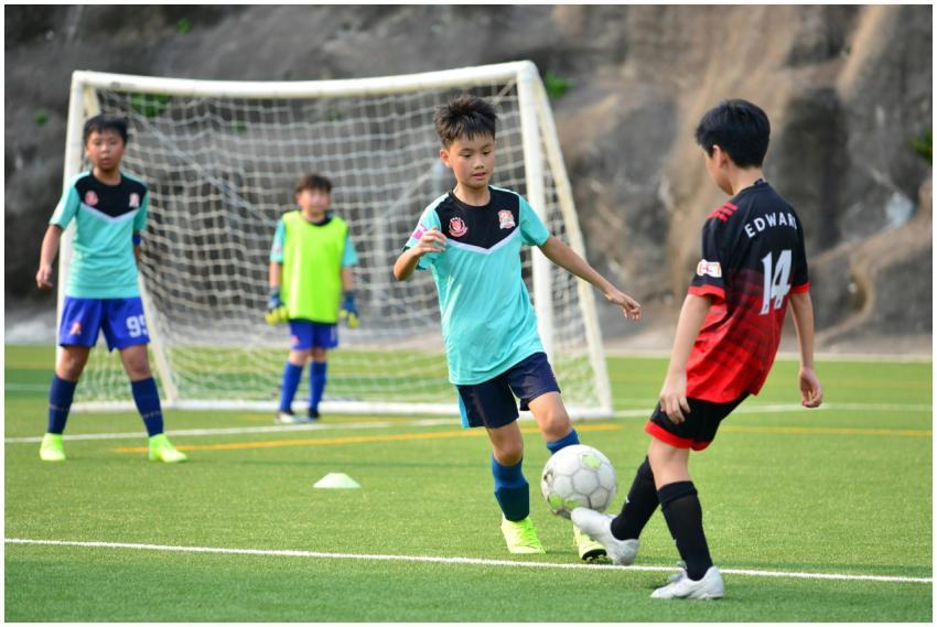 Boys playing soccer during a team training session