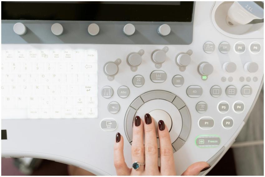 Hand operating a high-tech ultrasound control pane