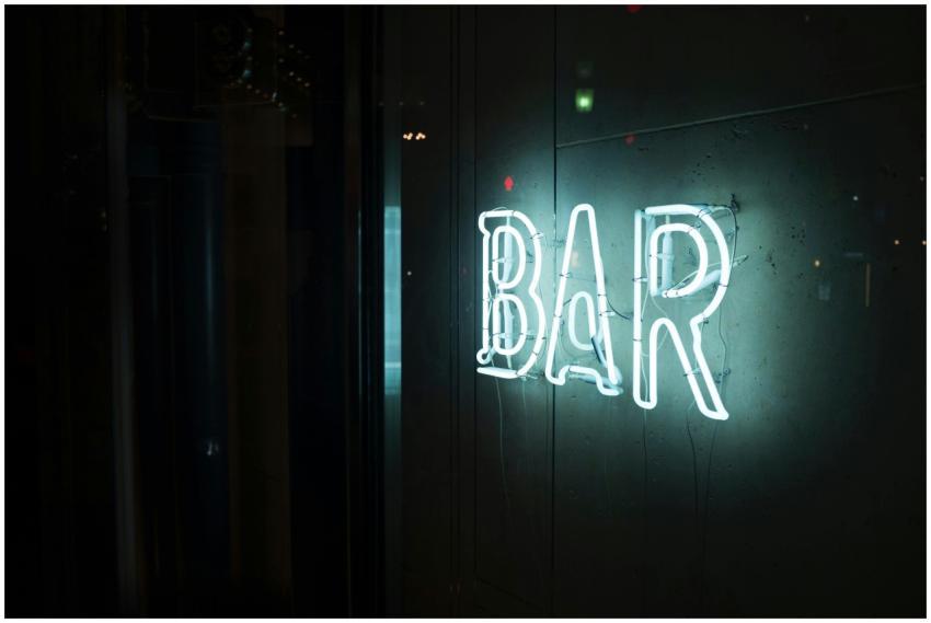 A glowing neon 'BAR' sign casting a bright light o