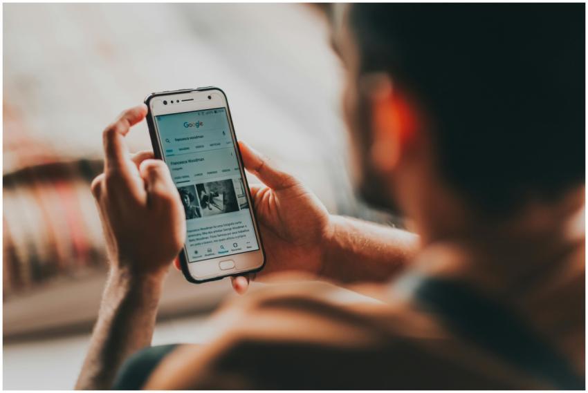 Back view of crop anonymous young male reading new