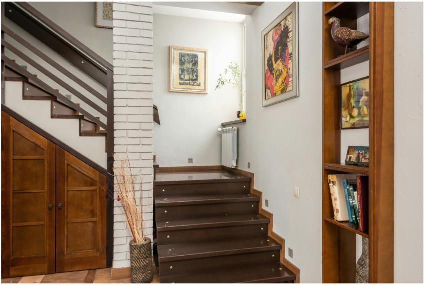 Cozy interior with a modern staircase, bookshelf,