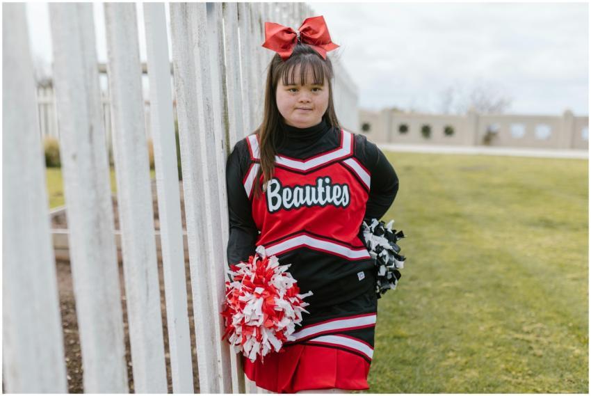 Young cheerleader with Down syndrome outdoors in v
