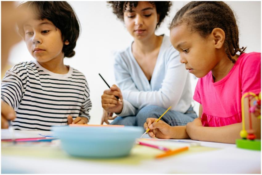 Children painting and learning with a teacher in a
